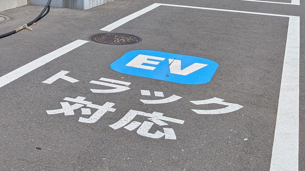 駐車枠の路面に、青地の「EV」表示と白い「トラック対応」の文字が大きく書かれている