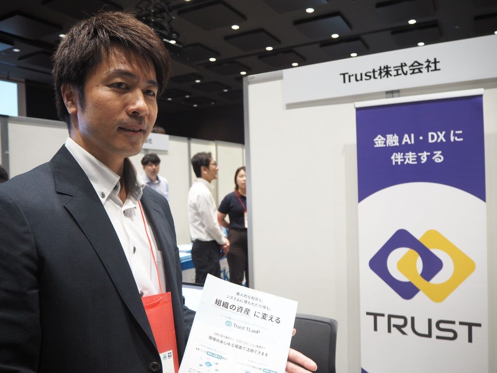 「保険EXPO 2026」の展示ブースでTLanPを紹介するTrust株式会社AI・データ事業部の田中稔氏